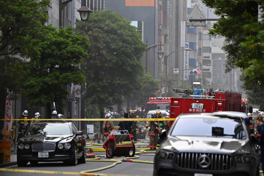 Firefighters gather at the fire scene in the Shinbashi area of Tokyo on July 3, 2023.  Photo by Kazuhiro NOGI / AFP
