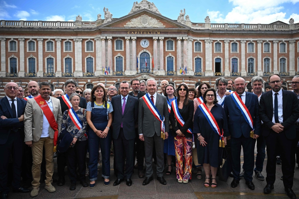 Mayor of Toulouse Jean-Luc Moudenc (centre) poses with participants during a nationwide action in Toulouse, southern France on July 3, 2023, after France's mayors have called on the population and elected representatives to gather in front of all town halls at midday, invoking 