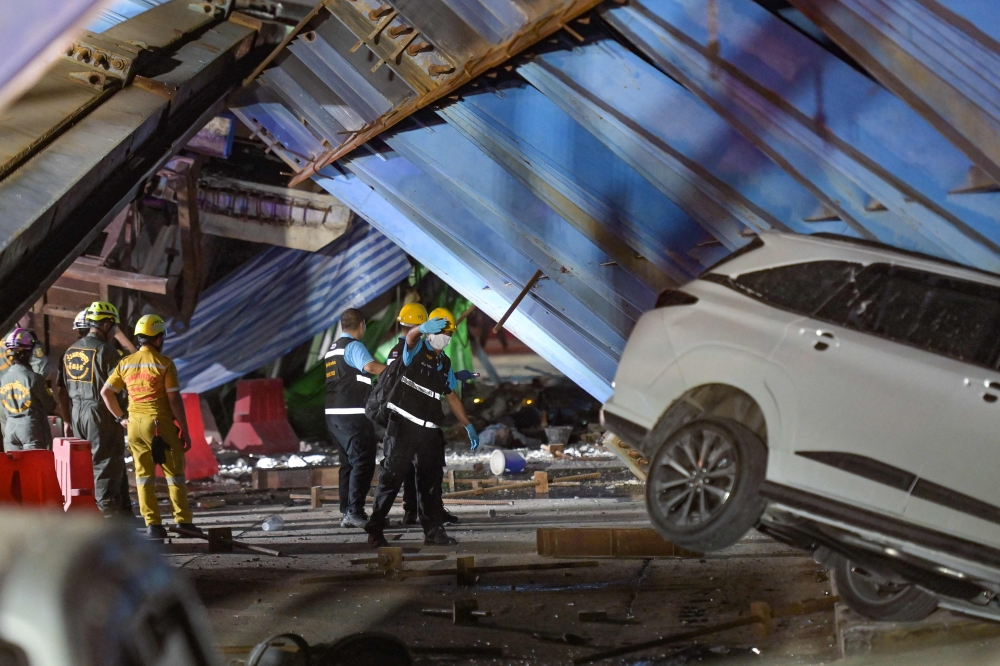 Forensic police and rescue workers inspect the scene after a construction girder on an elevated tollway collapsed, killing at least one person, in Lat Krabang district in Bangkok on July 10, 2023. (Photo by Tananchai KEAWSOWATTANA / THAI NEWS PIX / AFP)