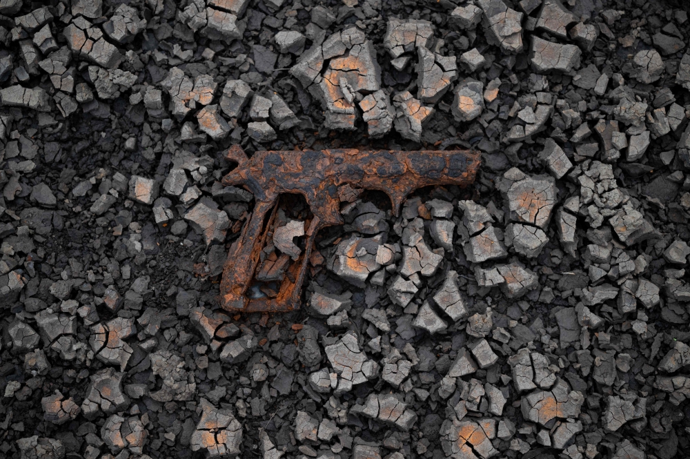 A previously submerged rusty hand gun is pictured on the dry bed of Woodhead Reservoir, revealed by a falling water level, near Glossop, northern England on July 10, 2023. (Photo by Oli Scarff / AFP)