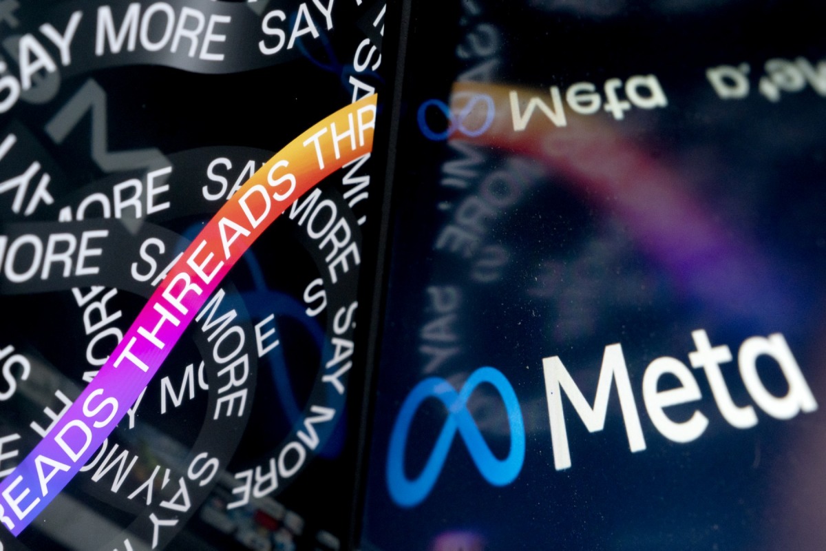 This photo illustration created in Washington, DC, on July 6, 2023, shows the opening page of Threads, an Instagram app, near the Meta logo. Photo by Stefani Reynolds / AFP