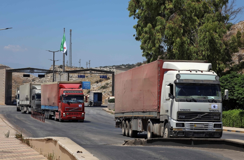 File Photo: A picture taken on July 28, 2022 shows the entry of the first United Nations aid convoy through the Bab al-Hawa border crossing with Turkey, after the decision to extend the authorisation mechanism across the border. (Photo by Ahmad al-Atrash / AFP)