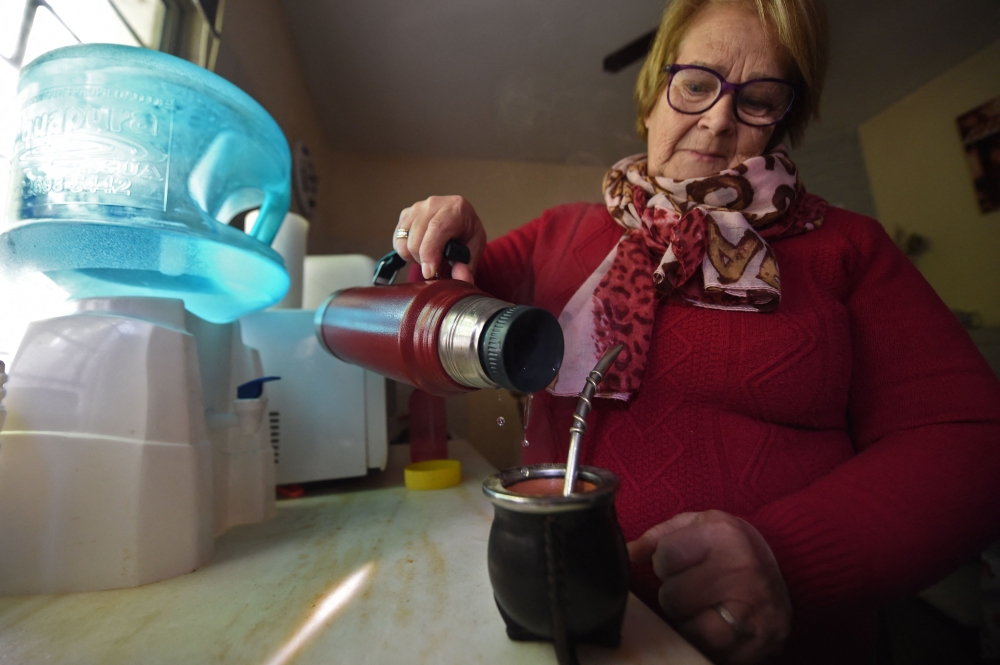 Uruguayan retired housewife Isabel Moreira pours hot water in her mate at her house in Montevideo on July 10, 2023, amid a severe drought that caused a water crisis in the country. (Photo by Dante Fernandez / AFP)