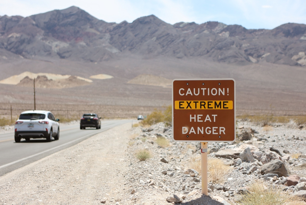 A heat advisory sign is shown along US highway 190 during a heat wave in Death Valley National Park in Death Valley, California, on July 16, 2023. (Photo by Ronda Churchill / AFP)