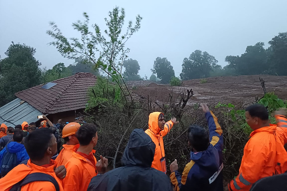 In this handout photograph released by India’s National Disaster Response Force (NDRF) and taken on July 20, 2023, NDRF personnel inspect the site of a landslide at Irshalwadi village of Raigad district in Maharashtra state. Photo by India’s National Disaster Response Force (NDRF) / AFP