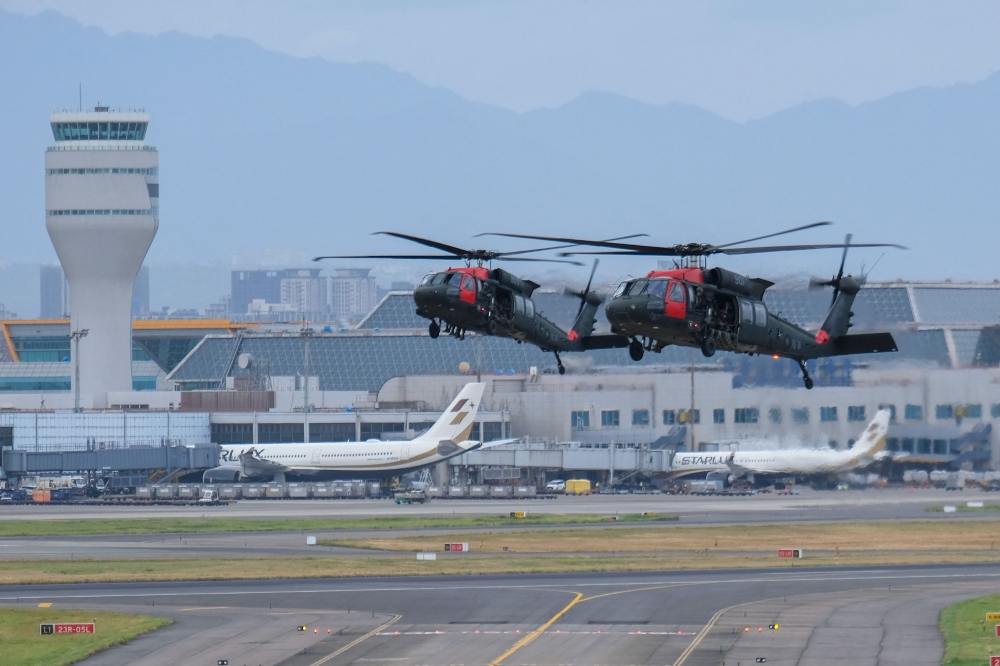 Taiwanese soldiers get out from US made Black Hawk helicopters during the military Han Guang drill at the Taoyuan International Airport on July 26, 2023. (Photo by Sam Yeh / AFP)