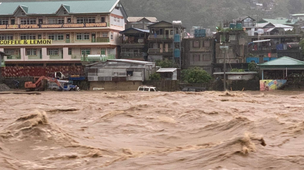 In this handout photo on July 26, 2023, vehicles are seen submerged as water rises along Chico River in Bontoc, Mountain Province. (Photo by Handout / Mountain Province Disaster Risk Reduction Management Office / AFP) 