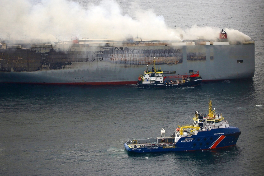 This handout photograph taken on July 28, 2023 from the Coast Guard plane and released on July 29, 2023 by the Dutch coastguards, shows a Multrasalvor 4 rescue vessel sailing next to a fire aboard the Panamanian-registered car carrier ship Fremantle Highway, after a fire broke out on the Fremantle Highway late on July 25, 2023, killing one crew member, and prompting a massive effort to extinguish the flames. Photo by Handout / Netherlands Coastguards / AFP