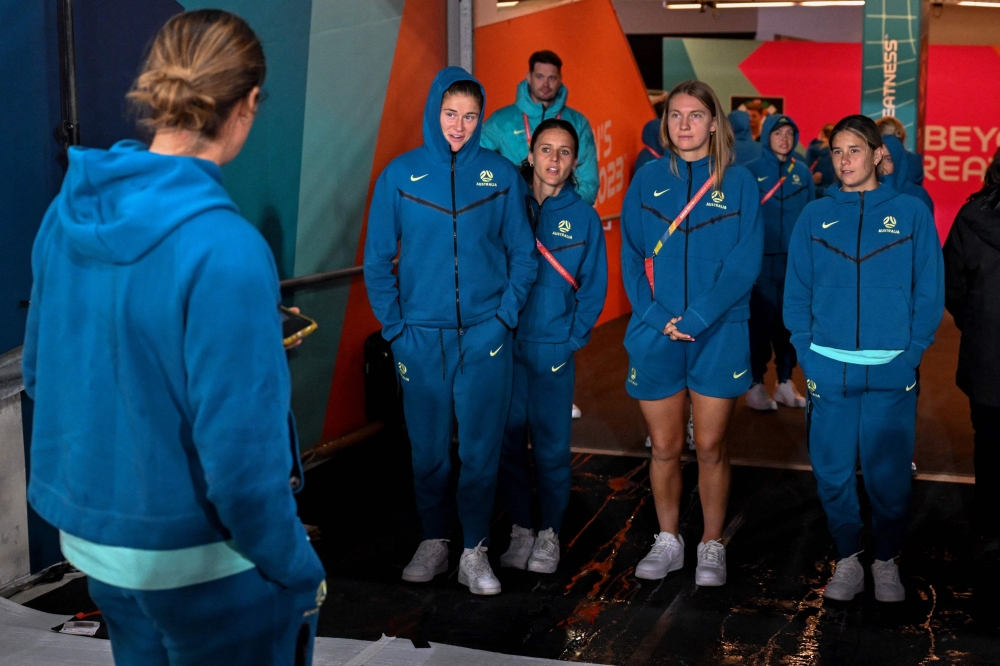 Australian players look out at the rain as they arrive at the Rectangular Stadium in Melbourne on July 30, 2023, on the eve of the Women's World Cup football match between Australia and Canada. (Photo by William WEST / AFP)