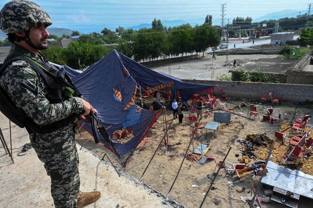 A security personnel stands guard next to the site of a bomb blast in Bajaur district of Khyber-Pakhtunkhwa province on July 31, 2023. (Photo by Abdul Majeed / AFP)