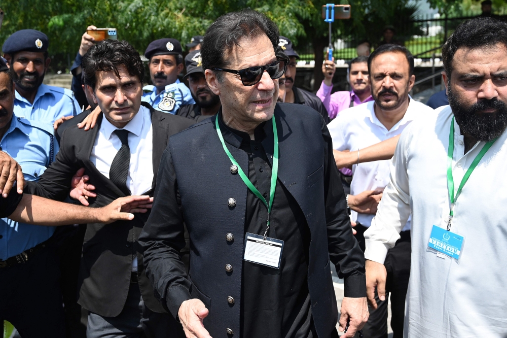 (Files) Pakistan's former Prime Minister Imran Khan (C) leaves after appearing in the Supreme Court in Islamabad on July 24, 2023. (Photo by Aamir Qureshi / AFP)