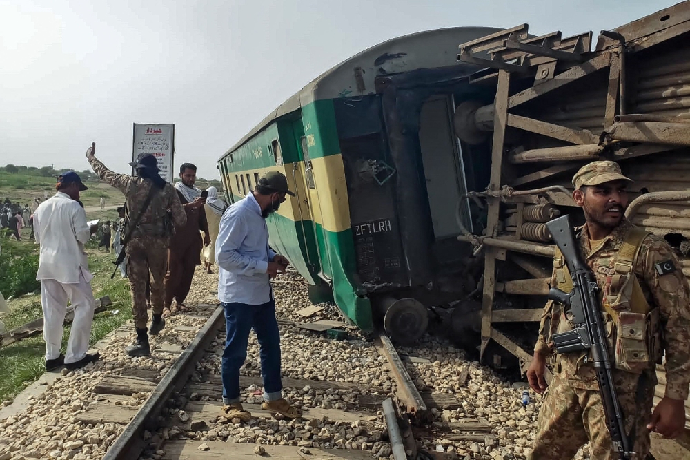 Paramilitary Rangers inspect the carriages following the derailment of a passenger train in Nawabshah, in the Pakistan's southern Sindh province on August 6, 2023. At least 19 people were killed and dozens injured on August 6 when an express train derailed in southern Pakistan, the country's railways minister said. (Photo by AFP)
