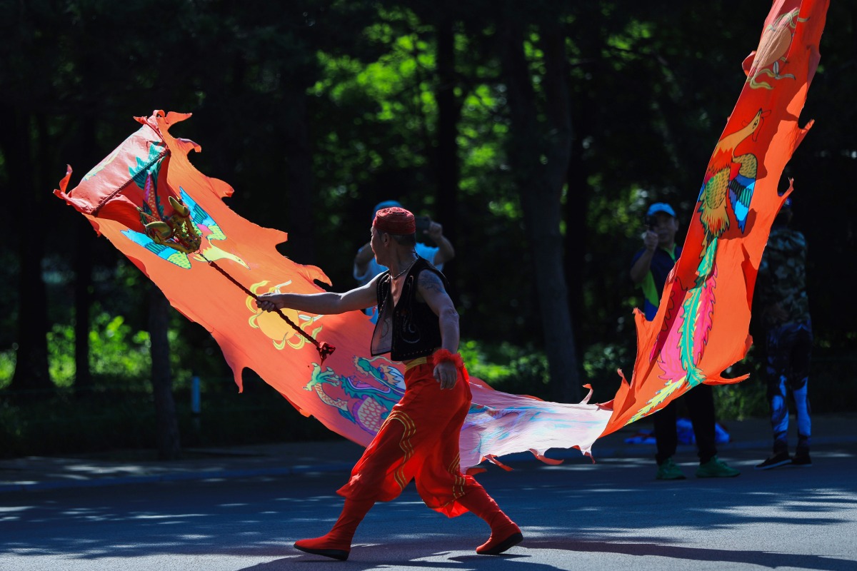 A man waves a ribbon at a park for morning exercise in Shenyang, in China's northeastern Liaoning province on August 8, 2023. Photo by AFP