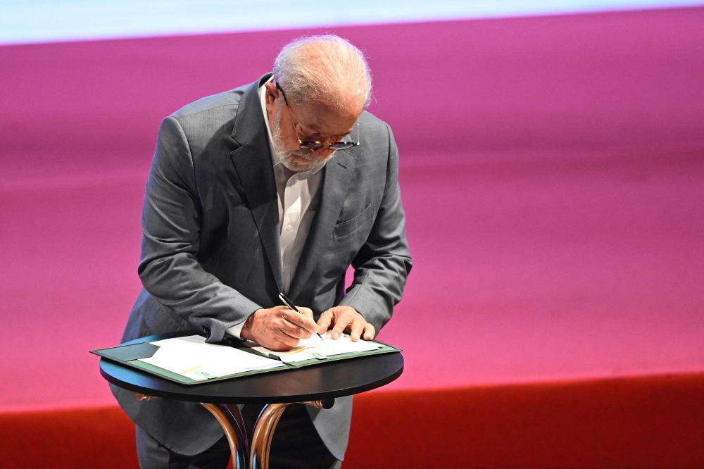 Brazilian President Luiz Inacio Lula da Silva signs the federal government's PAC (Growth Accelerated Program) during its launching ceremony at the Municipal Theater in Rio de Janeiro, Brazil on August 11, 2023. (Photo by MAURO PIMENTEL / AFP)
