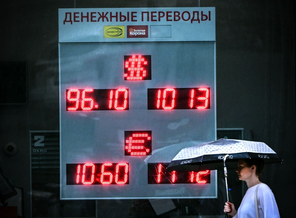 A woman walks past a currency exchange office in Moscow on August 14, 2023. (Photo by Yuri Kadobnov / AFP)