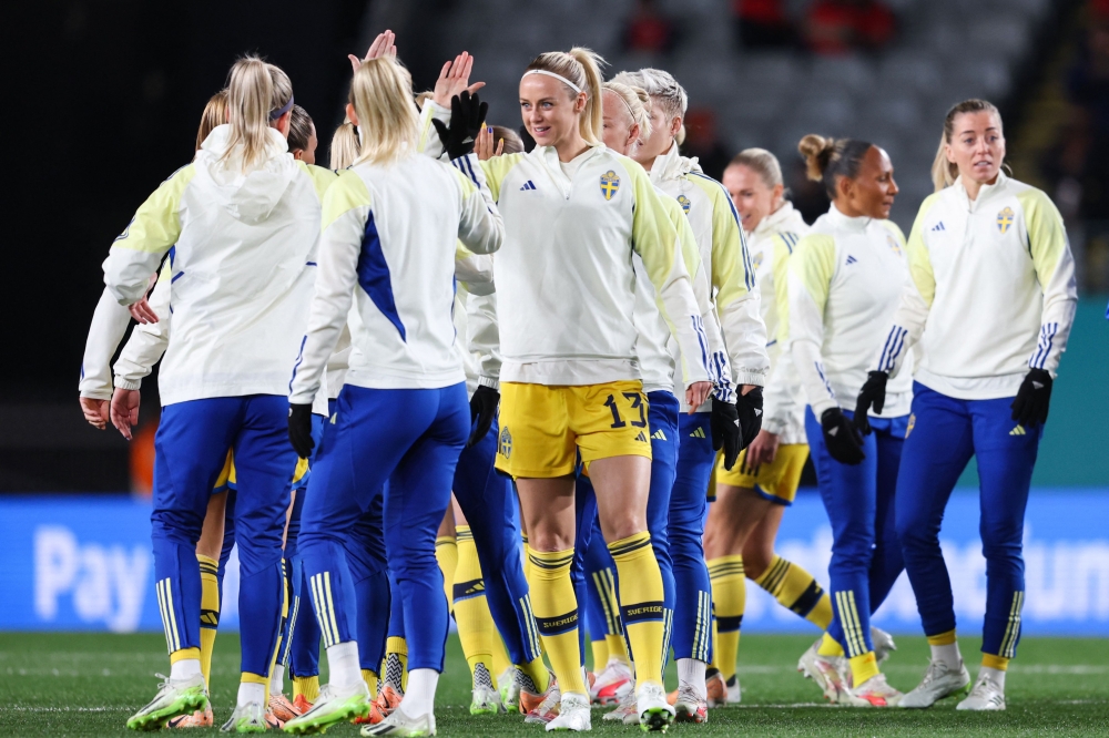 Sweden's defender #13 Amanda Ilestedt (C) high-fives a teammate during warm-ups before the start of the Australia and New Zealand 2023 Women's World Cup semi-final football match between Spain and Sweden at Eden Park in Auckland on August 15, 2023. (Photo by Michael Bradley / AFP)