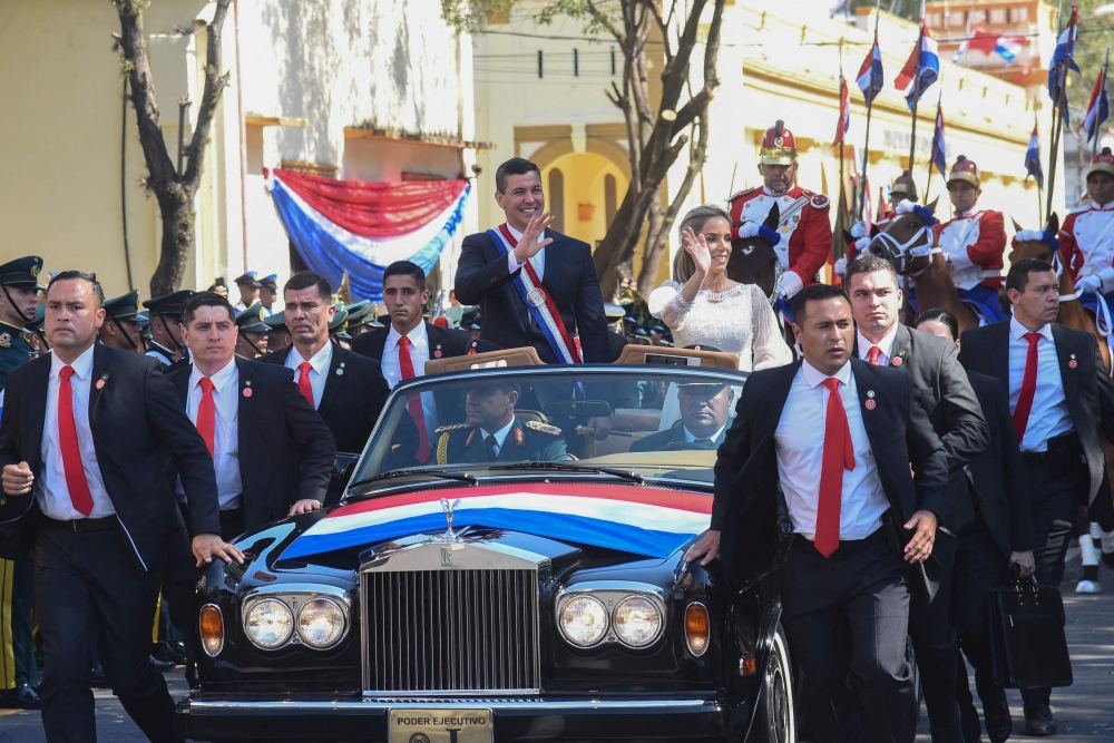 Paraguay's new President Santiago Pena and his wife First Lady Leticia Ocampos wave at supporters after being sworn in, in Asuncion on August 15, 2023. (Photo by Daniel Duarte / AFP)