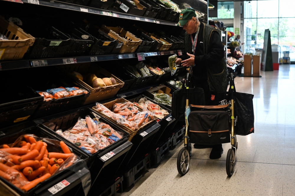 A customer looks at some vegetables at the Asda supermarket, in Amesbury, England, on August 15, 2023. Photo by JUSTIN TALLIS / AFP