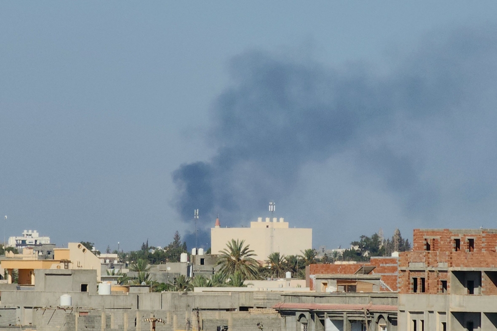 Smoke billows amid clashes between armed groups affiliated with Libya's Tripoli-based Government of National Unity (GNU) in the Libyan capital on August 15, 2023. (Photo by Mahmud TURKIA / AFP)