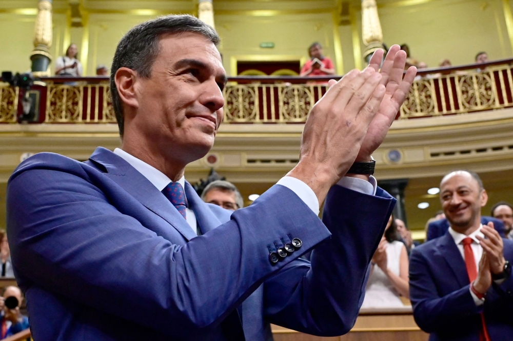 Acting Prime Minister Pedro Sanchez claps as he arrives to attend the Parliament's constitutive sitting at the Congress of Deputies in Madrid on August 17, 2023. (Photo by Javier Soriano / AFP)