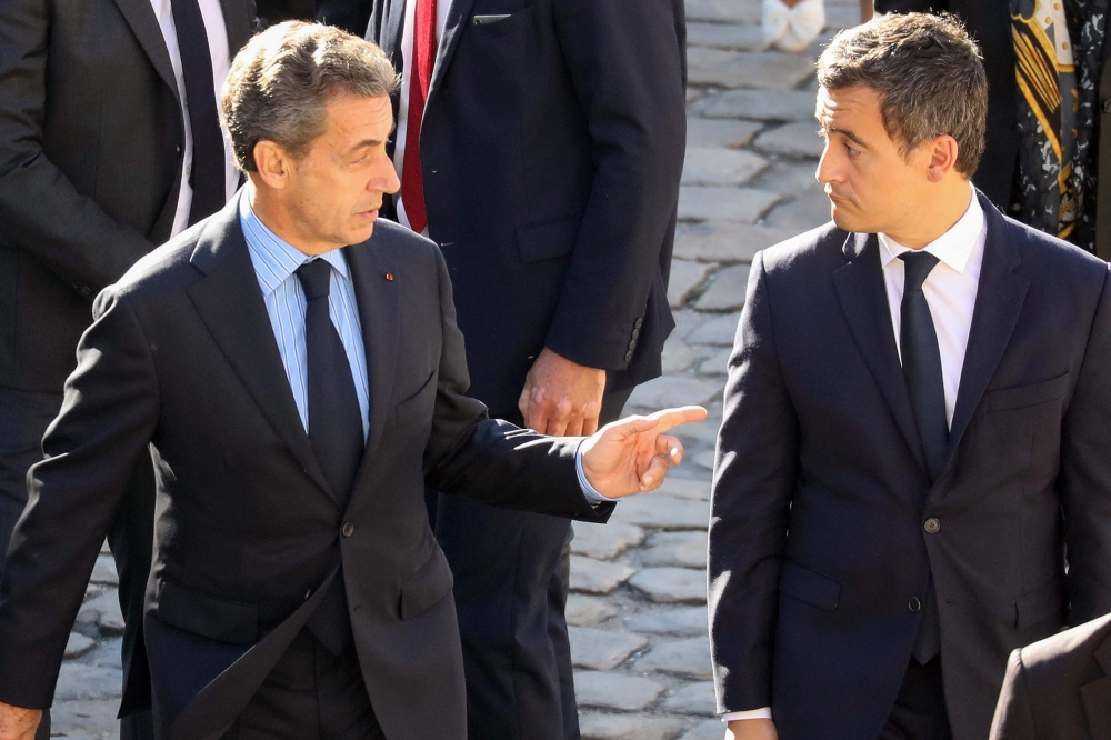 (Files) Former French President Nicolas Sarkozy (L) and French Minister of Public Action and Accounts Gerald Darmanin attend the national tribute to French-Armenian singer-songwriter Charles Aznavour at the Invalides in Paris on October 5, 2018. (Photo by Ludovic Marin / AFP)
 