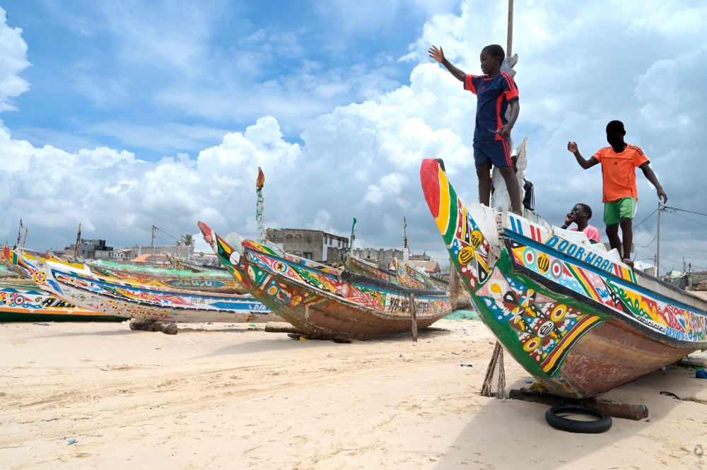 Young boys play on a pirogue in Fass Boye on August 17, 2023 after a pirogue capsized off the coast of Cape Verde. (Photo by SEYLLOU / AFP)
