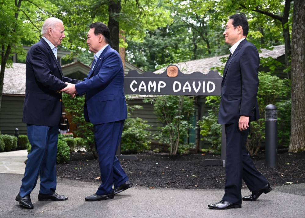 US President Joe Biden (left) welcomes South Korean President Yoon Suk Yeol (centre) and Japanese Prime Minister Fumio Kishida to Camp David, Maryland, for a Trilateral Summit on August 18, 2023. (Photo by Jim Watson / AFP)