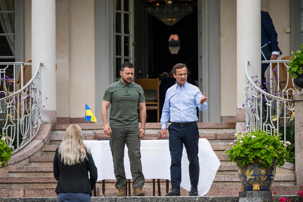 Ukrainian President Volodymyr Zelensky and Swedish Prime Minister Ulf Kristersson take a walk in the garden of the minister's countryside retreat in Harpsund, south-west of Stockholm, Sweden on August 19, 2023. (Photo by Jonathan NACKSTRAND / AFP)

