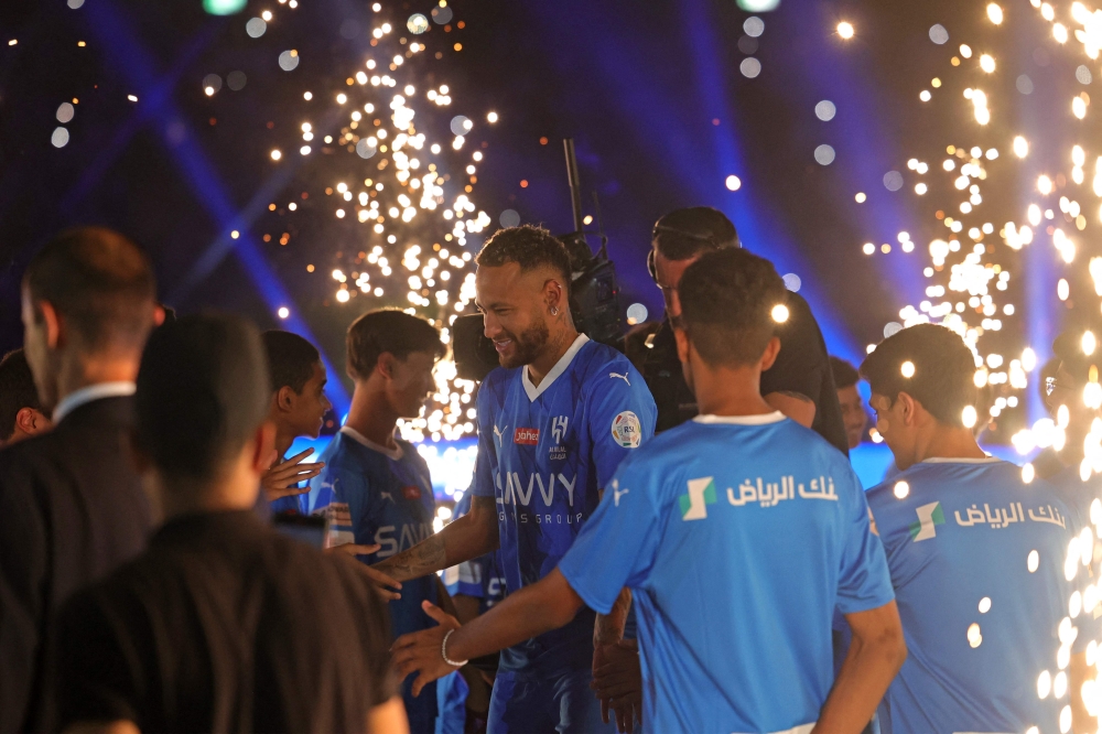 Brazilian superstar Neymar enters the pitch during his unveiling ceremony at Al-Hilal in Riyadh on August 19, 2023 as he becomes the latest world-famous footballer snapped up by the big-spending Saudi Pro League. (Photo by Fayez Nureldine / AFP)
