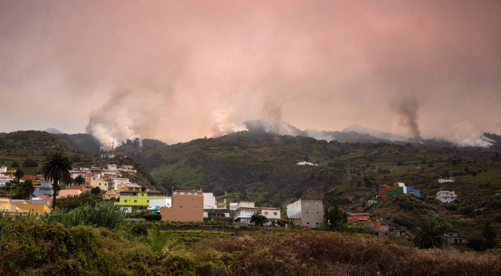 A wildfire rages out of control through forested slopes in La Matanza on the Canary island of Tenerife on August 19, 2023. Photos by DESIREE MARTIN / AFP