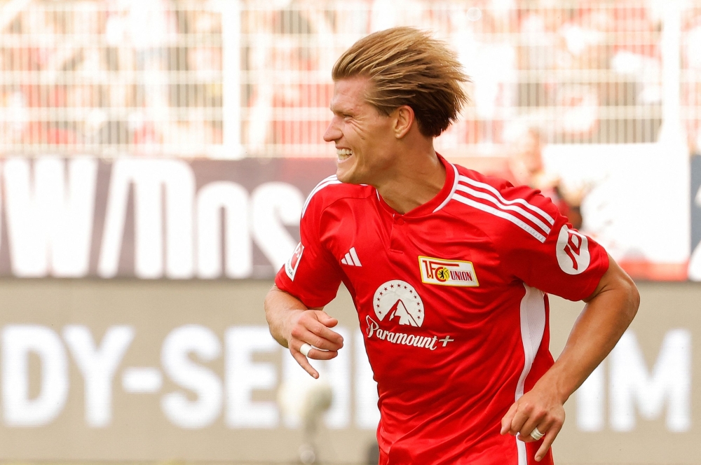 Union Berlin's German forward #17 Kevin Behrens celebrates scoring the 3-0 goal, his hattrick, with his teammates during the German first division Bundesliga football match between 1 FC Union Berlin and 1 FSV Mainz 05 in Berlin on August 20, 2023. (Photo by Odd ANDERSEN / AFP)