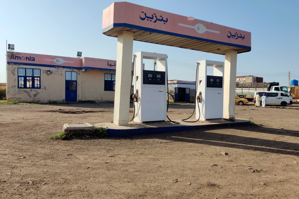 People stand next to an empty petrol station amid soaring fuel prices in Sudan's eastern city of Gedaref on August 19, 2023. (Photo by AFP)