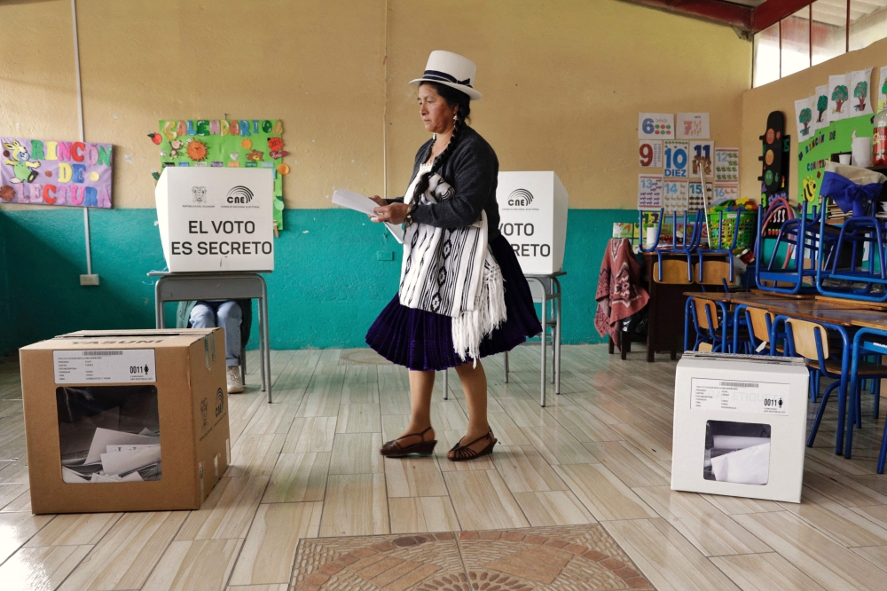 An Indigenous woman casts her vote at a polling station in Tarqui, canton of Cuenca, Azuay Province, during the Ecuadorean presidential election and referendum on mining and petroleum, on August 20, 2023. (Photo by Cristina Vega Rhor / AFP)