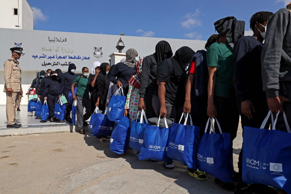 Nigerian migrants who voluntarily chose to return to their home country board a bus before flying out of Libya, during an operation organised by the the International Organisation for Migration (IOM) in Tripoli on August 21, 2023. (Photo by Mahmud Turkia / AFP)