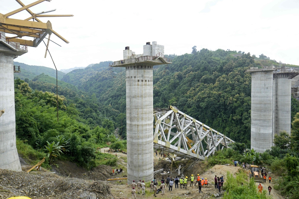 Rescue workers conduct a search operation at the site of an accident where an under-construction railway bridge collapsed in Sairang town of the Aizwal district in India's eastern state of Mizoram on August 23, 2023. (Photo by AFP)