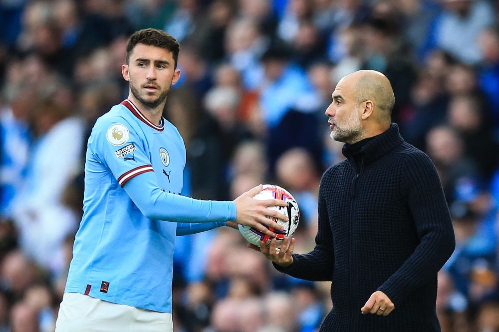 (FILES) Manchester City's Spanish manager Pep Guardiola (R) speaks to Manchester City's French defender Aymeric Laporte during the English Premier League football match between Manchester City and Leicester City at the Etihad Stadium in Manchester, north west England, on April 15, 2023. (Photo by Lindsey Parnaby / AFP)
