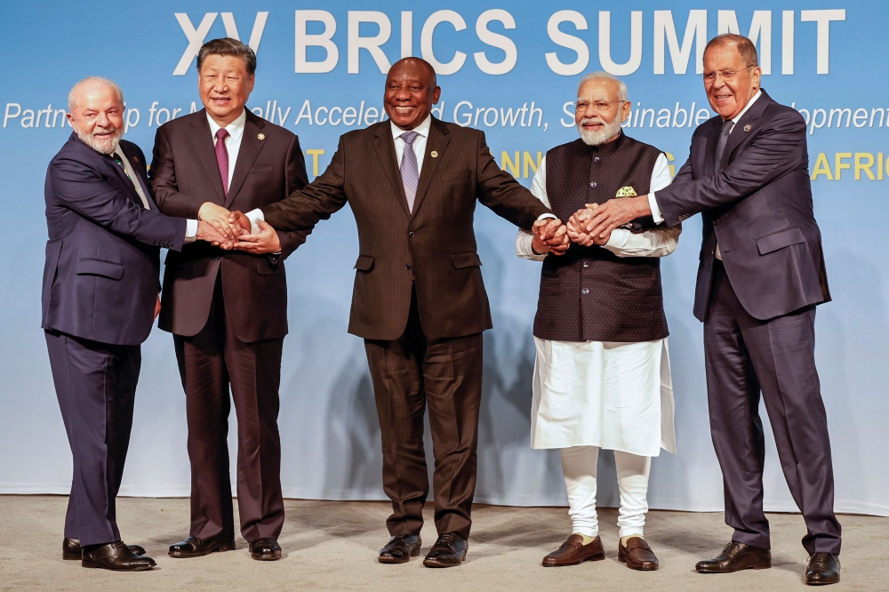 (From left) President of Brazil Luiz Inacio Lula da Silva, President of China Xi Jinping, South African President Cyril Ramaphosa, Prime Minister of India Narendra Modi and Russia's Foreign Minister Sergei Lavrov pose for a BRICS family photo during the 2023 BRICS Summit at the Sandton Convention Centre in Johannesburg on August 23, 2023. (Photo by Gianluigi Guercia / POOL / AFP)