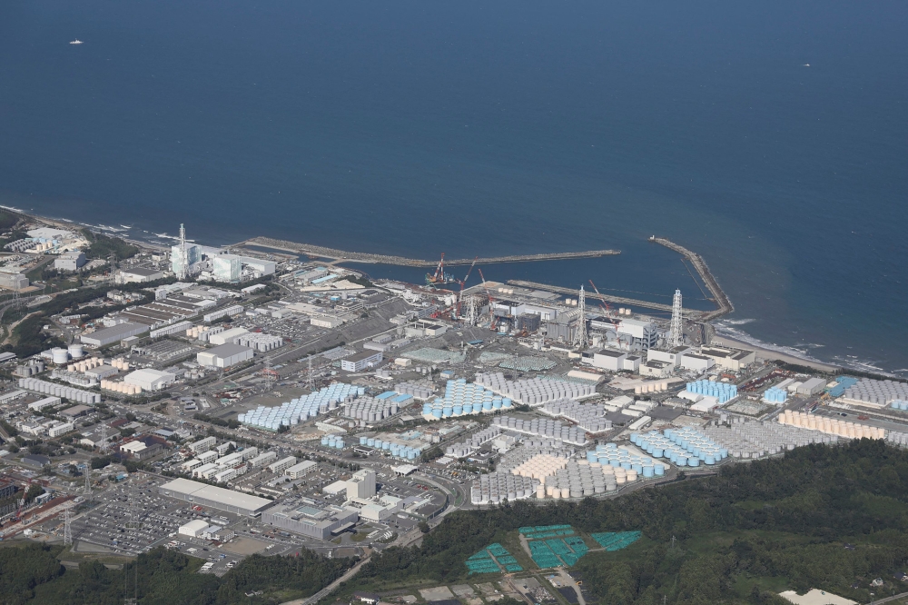 This aerial picture shows storage tanks (bottom) used for storing treated water at TEPCO's crippled Fukushima Daiichi Nuclear Power Plant in Okuma, Fukushima prefecture on August 24, 2023. Photo by JIJI PRESS / AFP