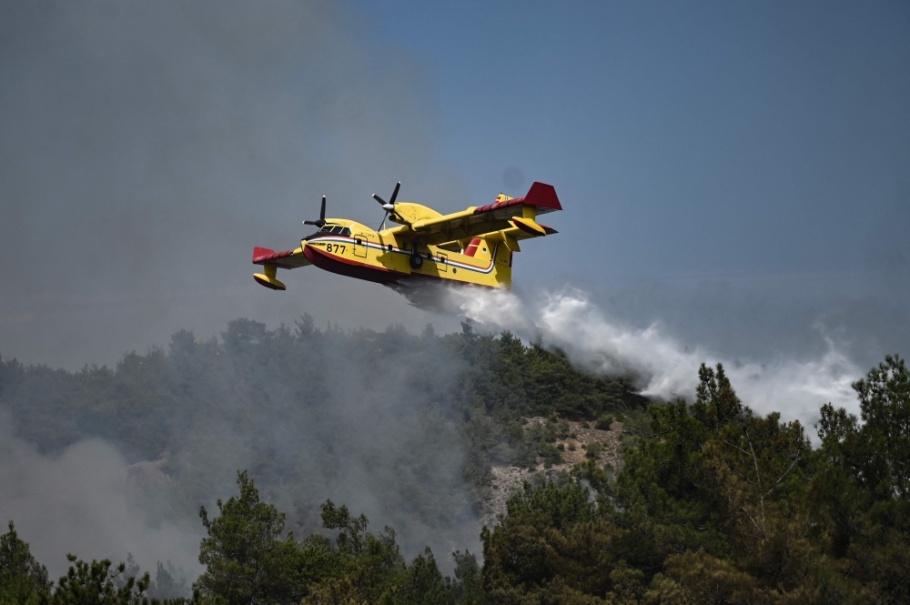 A picture taken on August 24, 2023 shows a Canadair amphibious aircraft, droping water over wildfires spreading in Dadia forest near Alexandroupoli, north Greece, on August 24, 2023. Photo by Sakis MITROLIDIS / AFP