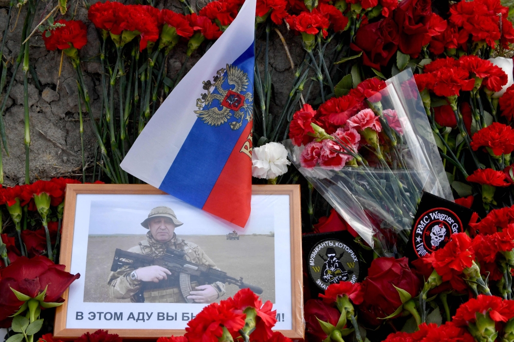 A portrait of Yevgeny Prigozhin is seen amid flowers at a makeshift memorial in front of the Private Military Company (PMC) Wagner Centre in Saint Petersburg, on August 25, 2023. (Photo by Olga Maltseva / AFP)