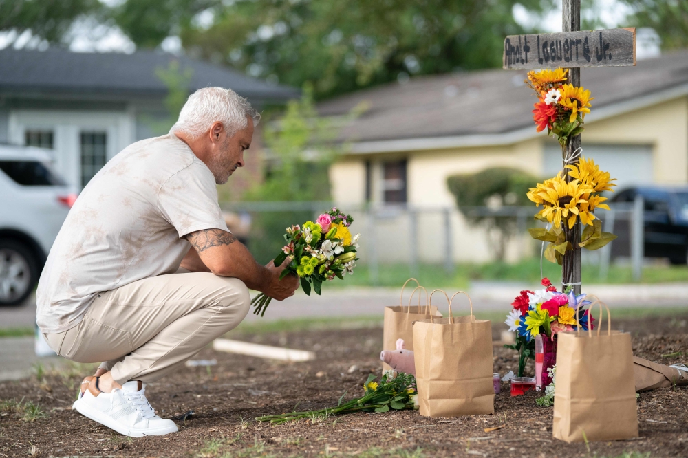 Will Walsh visits memorials for Jerrald Gallion, Angela Carr and Anolt Joseph Laguerre Jr. near a Dollar General store where they were shot and killed two days earlier on August 28, 2023 in Jacksonville, Florida. (Photo by Sean Rayford / GETTY IMAGES NORTH AMERICA / Getty Images via AFP)
