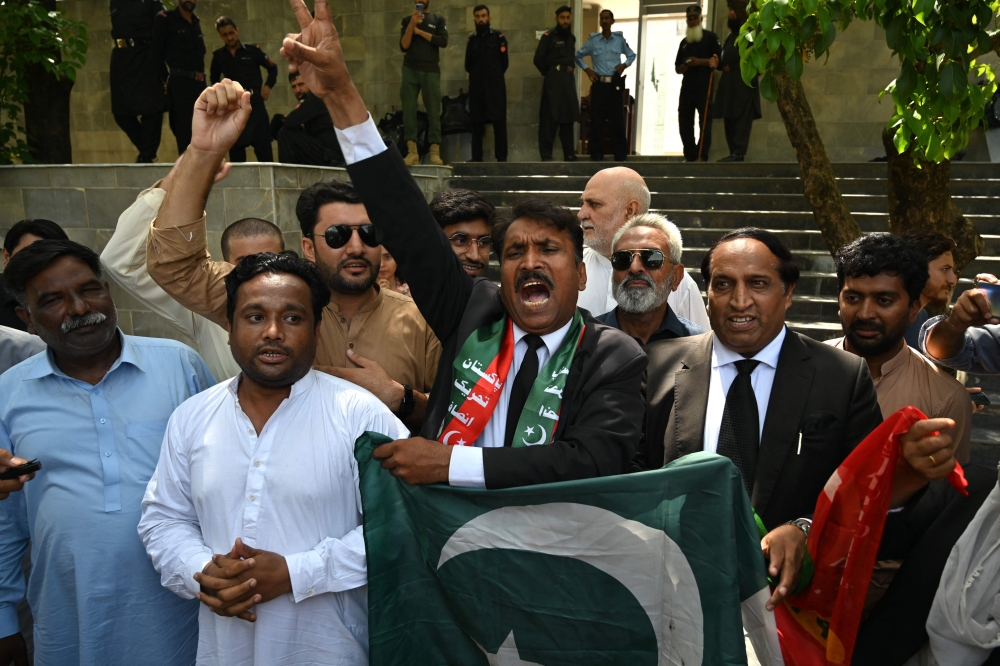 Lawyers and supporters of Pakistan's former Prime Minister Imran Khan, shout slogans as they celebrate outside the Islamabad High Court in Islamabad on August 29, 2023, after suspension of Khan's prison sentence for a graft conviction. (Photo by Farooq Naeem / AFP)