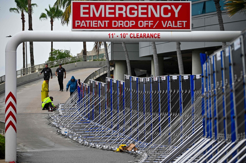 Workers set up a fence to prevent flooding at Tampa General Hospital in Tampa, Florida, on August 29, 2023 as the city prepares for Hurricane Idalia. Photo by Miguel J. Rodriguez Carrillo / Miguel J. Rodriguez Carrillo / AFP