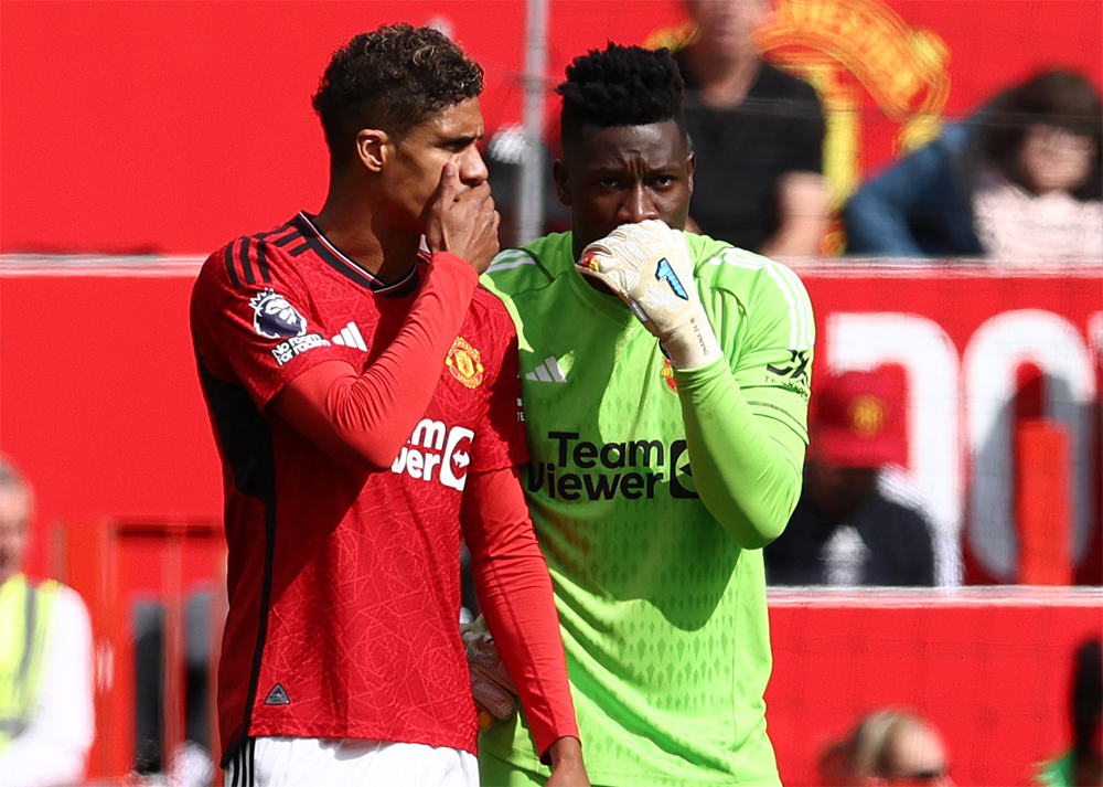 Manchester United's Cameroonian goalkeeper #24 Andre Onana whispers to Manchester United's French defender #19 Raphael Varane during the English Premier League football match between Manchester United and Nottingham Forest at Old Trafford in Manchester, northwest England, on August 26, 2023. Photo by Darren Staples / AFP