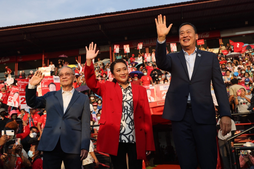 File photo: Thai candidates for prime minister Paetongtarn Shinawatra (C), Srettha Thavisin (R) and Chaikasem Nitisiri (L) wave to the crowd during an election rally for Thailand's main opposition Pheu Thai party at the Thunder Dome Stadium in Nonthaburi, north of the capital Bangkok, on April 5, 2023. (Photo by Jack Taylor / AFP)

