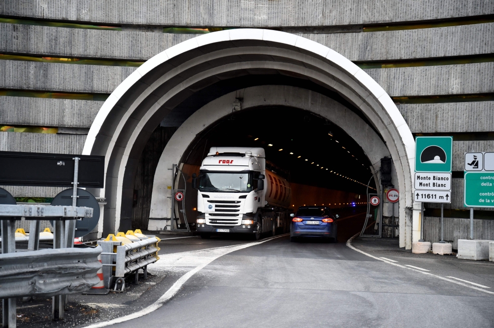 A truck gets out of the tunnel of the Mont-Blanc from Italy as a car enters on January 12, 2017 in Chamonix Mont-Blanc during the presentation of the new computerized safety control system of the Mont Blanc Tunnel, southeastern France. Photo by JEAN-PIERRE CLATOT / AFP