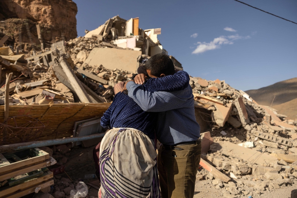 Family members react near the rubble of collapsed buildings in the village of Imi N'Tala near Amizmiz in central Morocco, on September 10, 2023. (Photo by Fadel Senna / AFP)