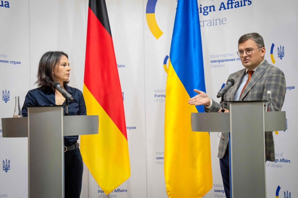 German Foreign Minister Annalena Baerbock (left) listens to Ukrainian Foreign Minister Dmytro Kuleba speaking during a joint news conference following their talks in Kyiv on September 11, 2023. (Photo by Efrem Lukatsky / POOL / AFP)