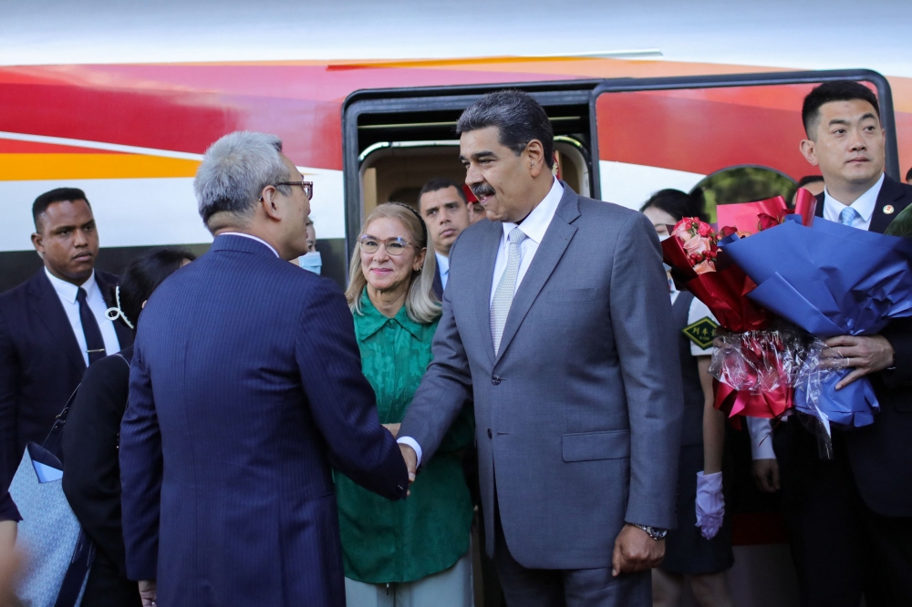 This handout photo taken and released by the Miraflores Presidential Palace Press Office on September 12, 2023 shows Venezuela's President Nicolas Maduro (centre R) and Venezuela's First Lady Cilia Flores (centre L) being received by Chinese officials. 