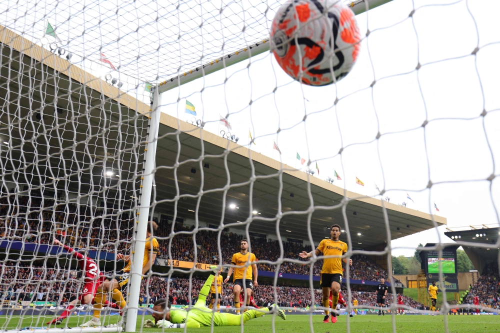 Liverpool's Scottish defender #26 Andrew Robertson (L) celebrates after scoring their second goal during the English Premier League football match between Wolverhampton Wanderers and Liverpool at the Molineux stadium in Wolverhampton, central England on September 16, 2023. (Photo by Adrian DENNIS / AFP)